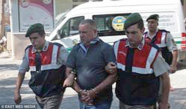 The gardener, known only as VA, 46, is lead away by Turkish jandarma.