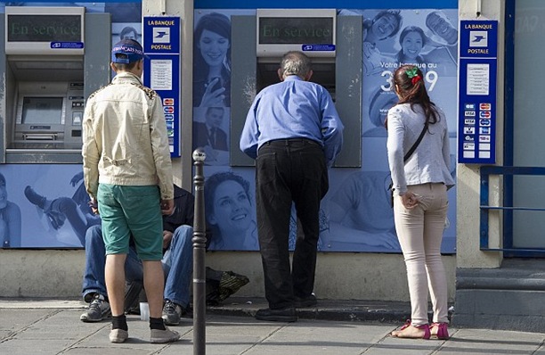 Watching the unsuspecting victim as he withdraws his cash