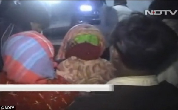 The woman, seen surrounded by family members as she is escorted into hospital, was locked in a shed and raped overnight by 13 men, ten of which had been 'judges' in the kangaroo court which sentenced her