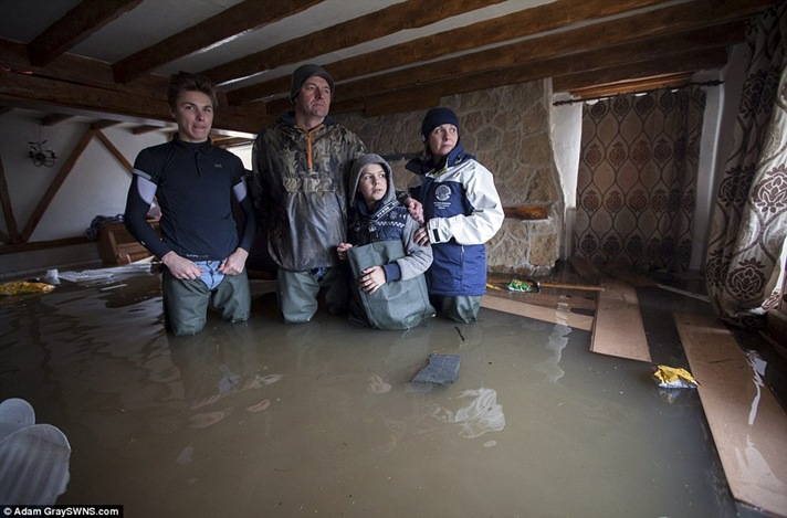 Mark and Kate Kirby with sons Dom, 16, left, and Theo, 10, in their devastated home in Moorland, Somerset Mark and Kate Kirby with sons Dom, 16, left, and Theo, 10, in their devastated home in Moorland, Somerset
