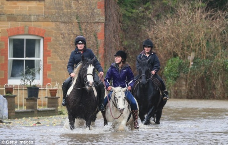 People ride horses through flood water near Langport in Somerset, England during this month's flash-flooding People ride horses through flood water near Langport in Somerset, England during this month's flash-flooding