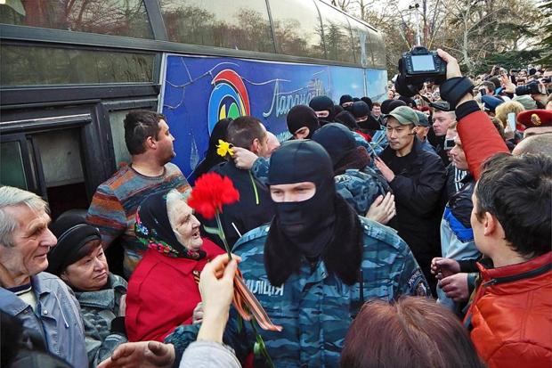 Russian troops in Crimea are given flowers, as the people beg them for defense from the revolution.
