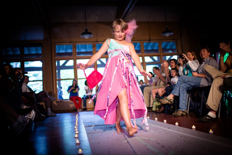 Family members applaud a camper as he makes his way down the long awaited fashion show runway.