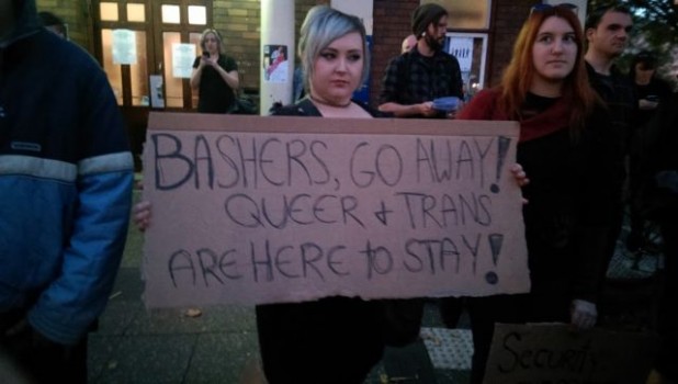 A protester holds a sign. But was it born male, female, or in a pig pen?