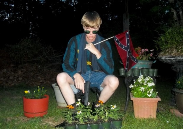 This undated image that appeared on Lastrhodesian.com, a website being investigated by the FBI in connection with Charleston, S.C., shooting suspect Dylann Roof, shows Roof posing for a photo while holding a Confederate flag. The website surfaced online Saturday, June 20, 2015, and also contained a hate-filled 2,500-word essay that talks about white supremacy and concludes by saying the author alone will need to take action. (Lastrhodesian.com via AP) MANDATORY CREDIT