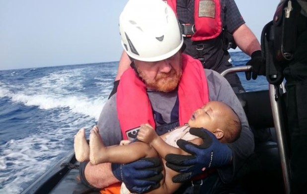 A German rescuer from the humanitarian organisation Sea-Watch holds a drowned migrant baby, off the Libyan cost May 27, 2016. Christian Buettner/Eikon Nord GmbH Germany/Handout via REUTERS