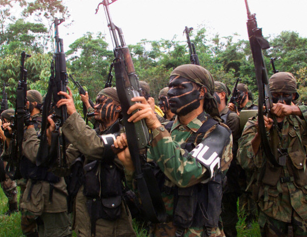 Colombian paramilitaries brandish their automatic assault weapons during a training session in the Colombian jungle in this file photo taken on May 4, 2000. Led by an articulate former army scout, Carlos Castano, the paramilitaries, known as the United Self-Defense Forces of Colombia (AUC), grew ninefold to 8,000 fighters in the eight years to 2000 accused of human rights abuses. The paramilitaries are now one of the biggest military problems for Colombia's guerrilla groups, which are fighting the regular armed forces as well. These have recently been bolstered by $1 billion in mainly military U.S. aid for the government's anti-drug "Plan Colombia". REUTERS/Jose Miguel Gomez/File photo --- Image by © Reuters/CORBIS