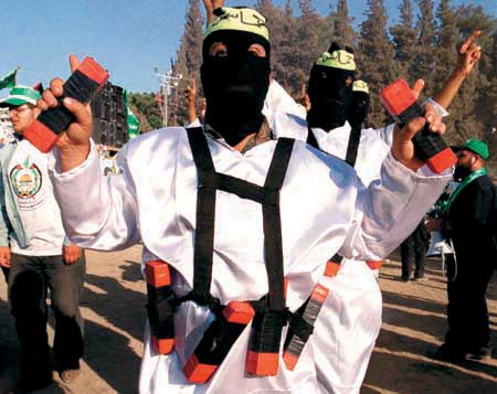 Palestinian dressed as suicide bombers wear mock explosives during a theatrical presention held at a massive anti-Israel rally in the West Bank town of Nablus Friday, Aug. 24, 2001. Over 50,000 Palestinians attended the rally in an display of unity between Yasser Arafat's Fatah movement and the militant Islamic group Hamas, which was once the main opposition to the Palestinian leader. (AP Photo/Nassser Ishtayeh)