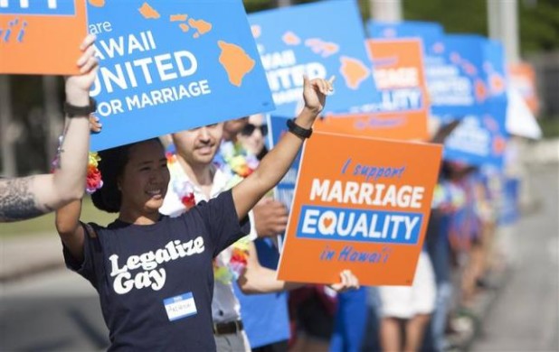 Keri Bias (L) holds a sign in support of same sex marriage in front of the Hawaii State Capital in Honolulu in this file photo taken October 28, 2013. REUTERS/Hugh Gentry/Files